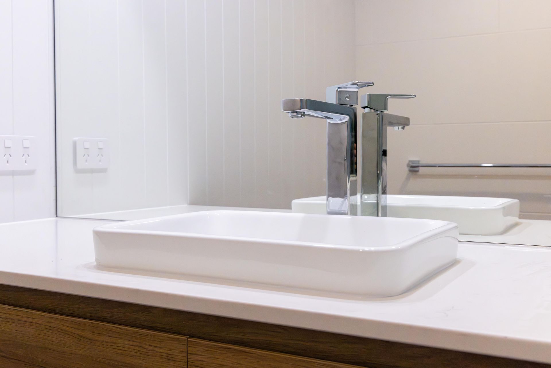 A bathroom sink with a faucet and a mirror.