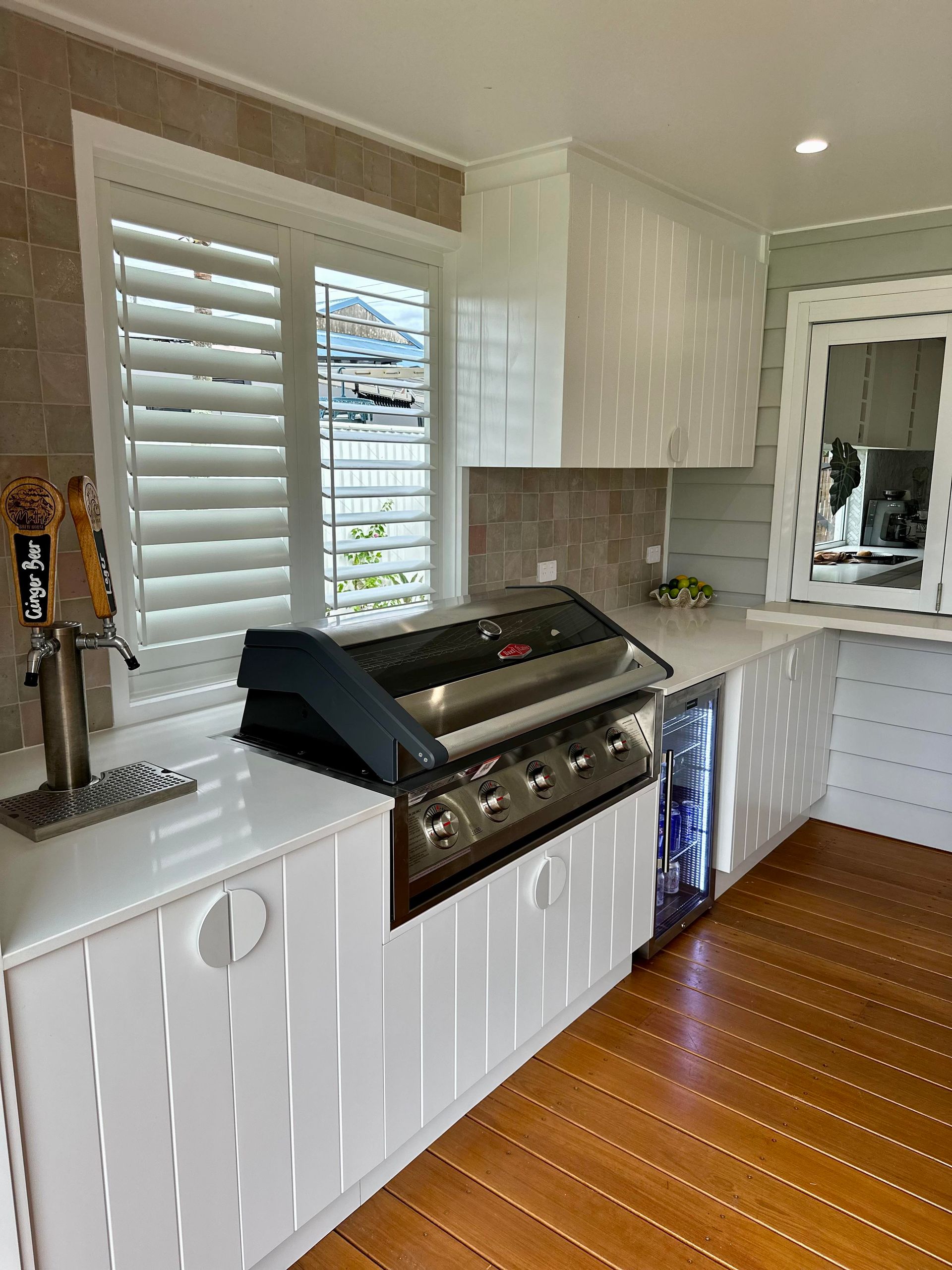A kitchen with a grill and a window with shutters.