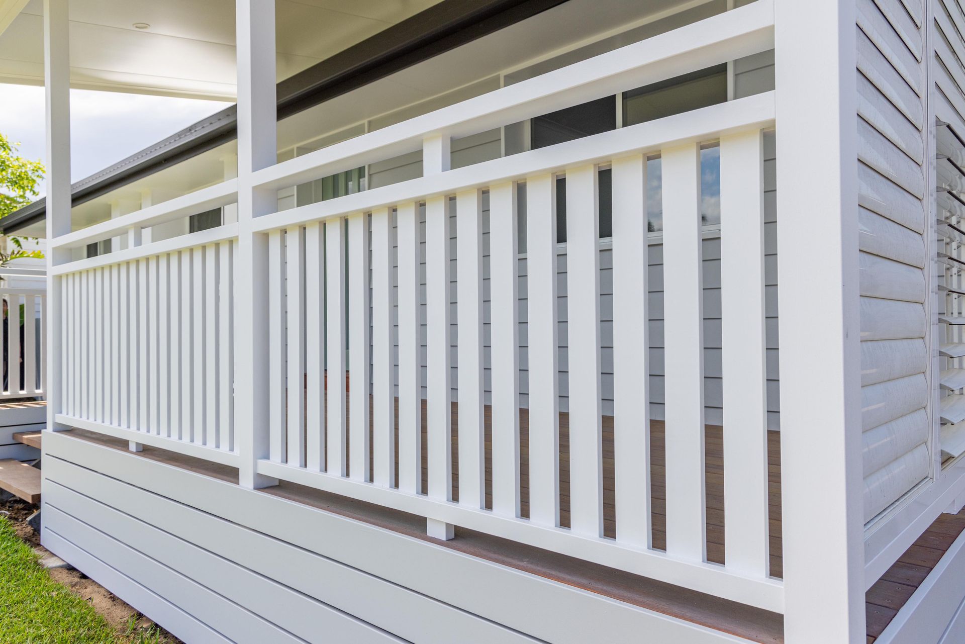 A white railing on a porch of a house.