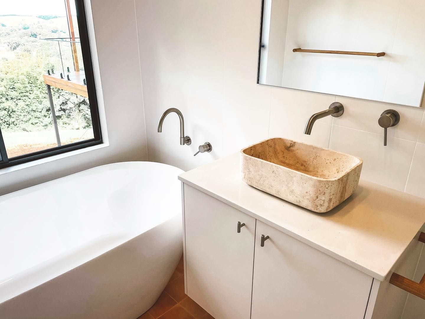 A bathroom with a sink , bathtub and mirror.