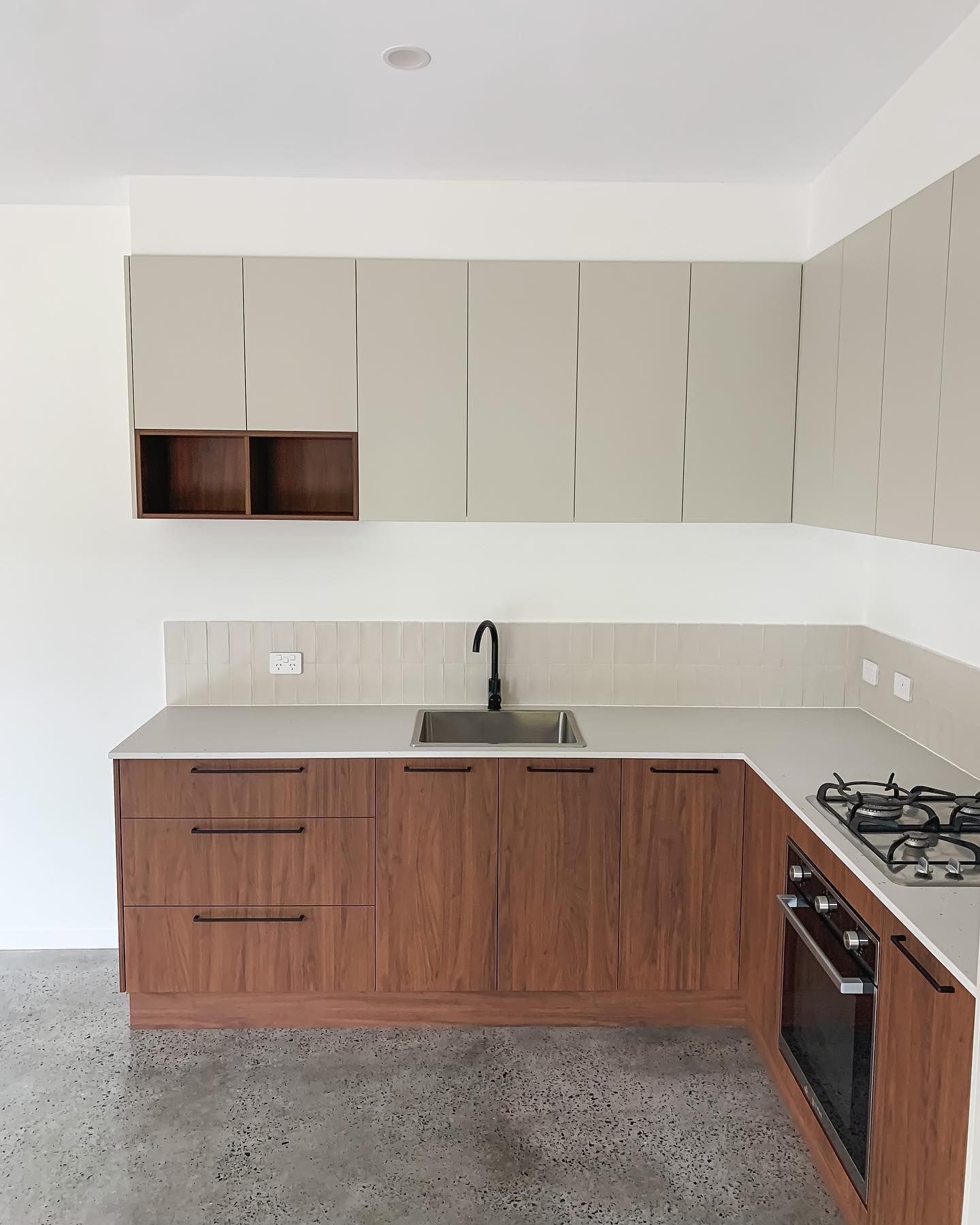 A kitchen with wooden cabinets , a sink , and a stove.