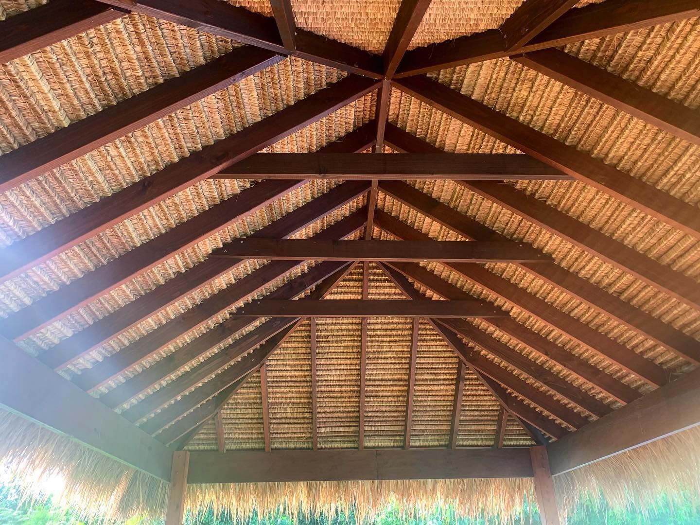 A wooden structure with a thatched roof and wooden beams.