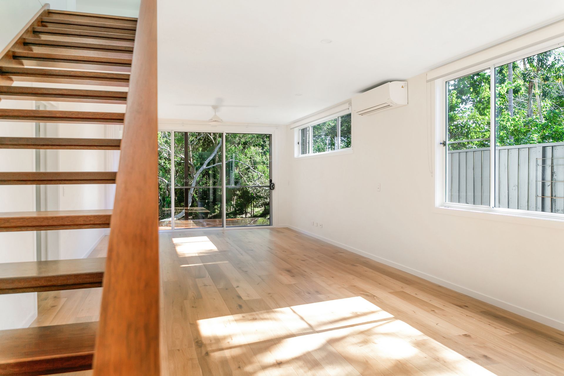 There is a wooden staircase in the middle of the room.