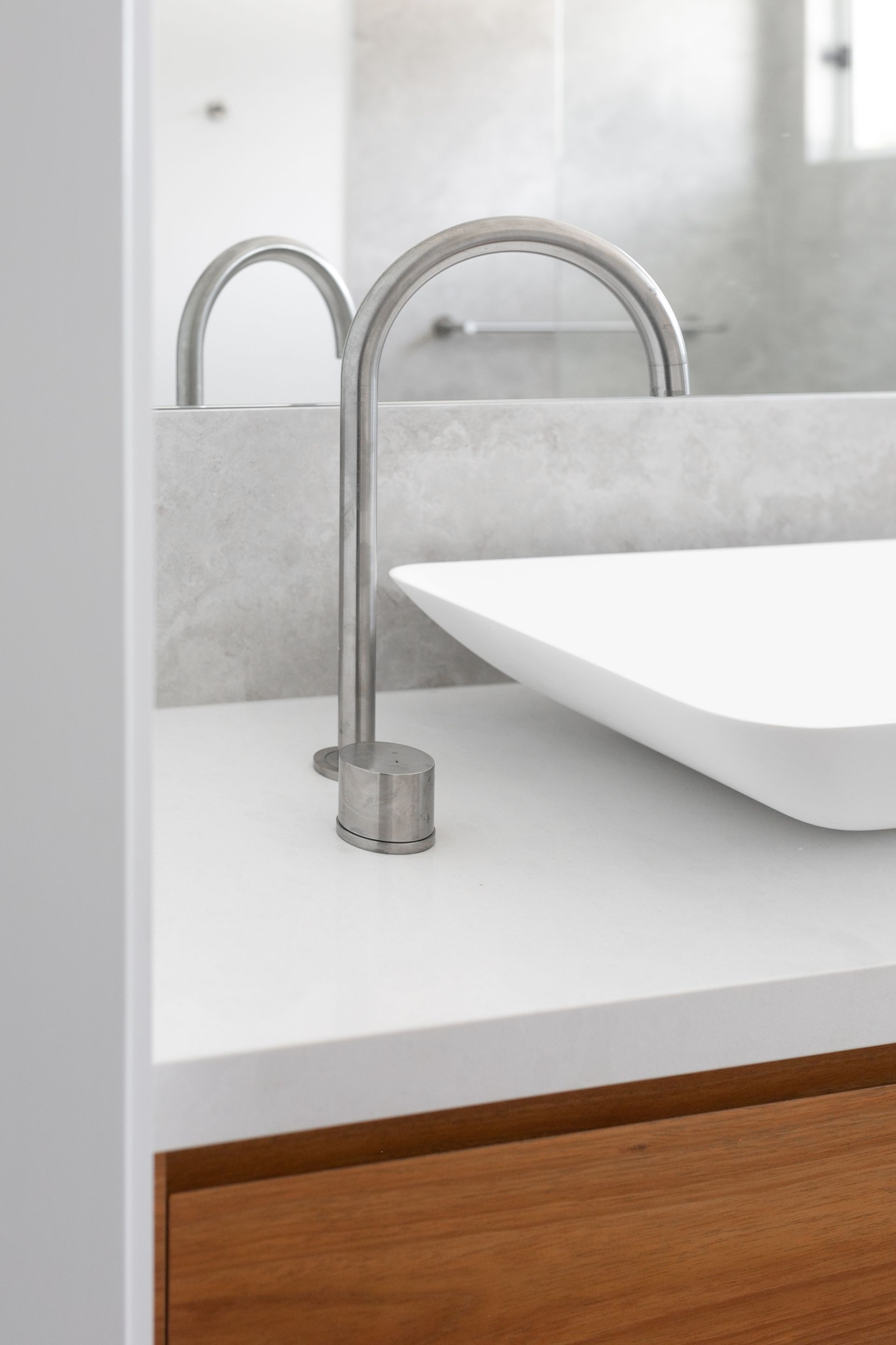 A bathroom sink with a faucet and a mirror.
