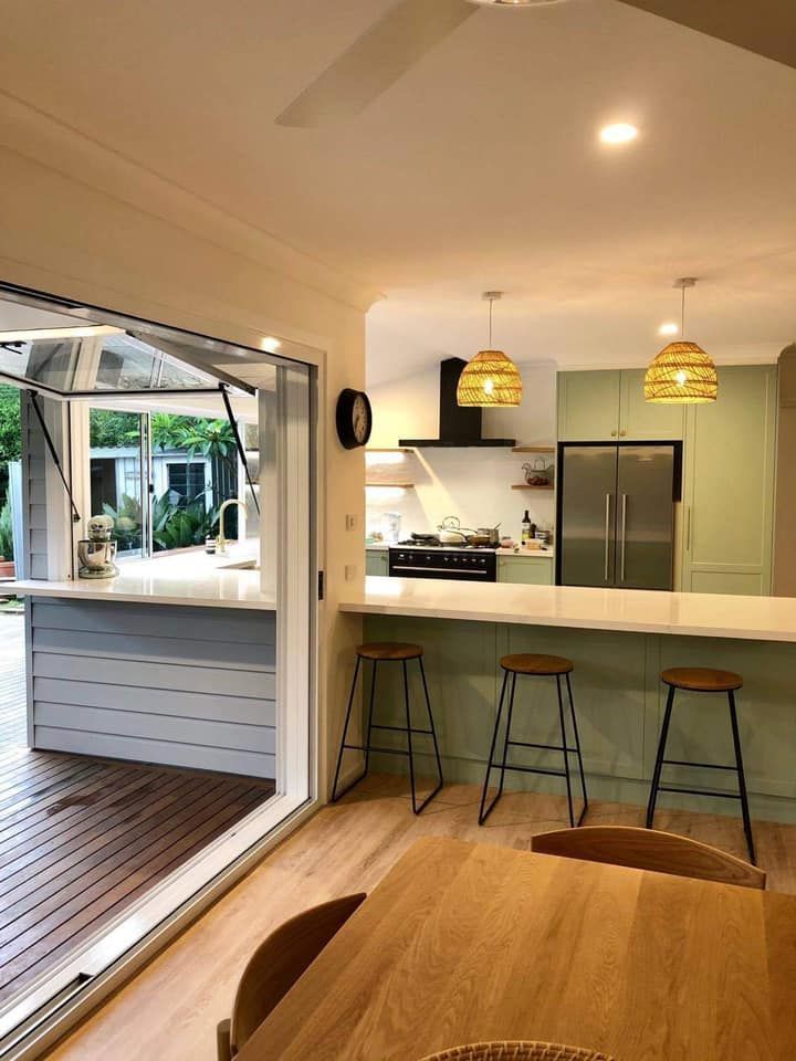 A kitchen with a table and chairs and a sliding glass door leading to a deck.