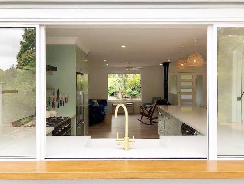 A kitchen with a sink and a sliding glass door.