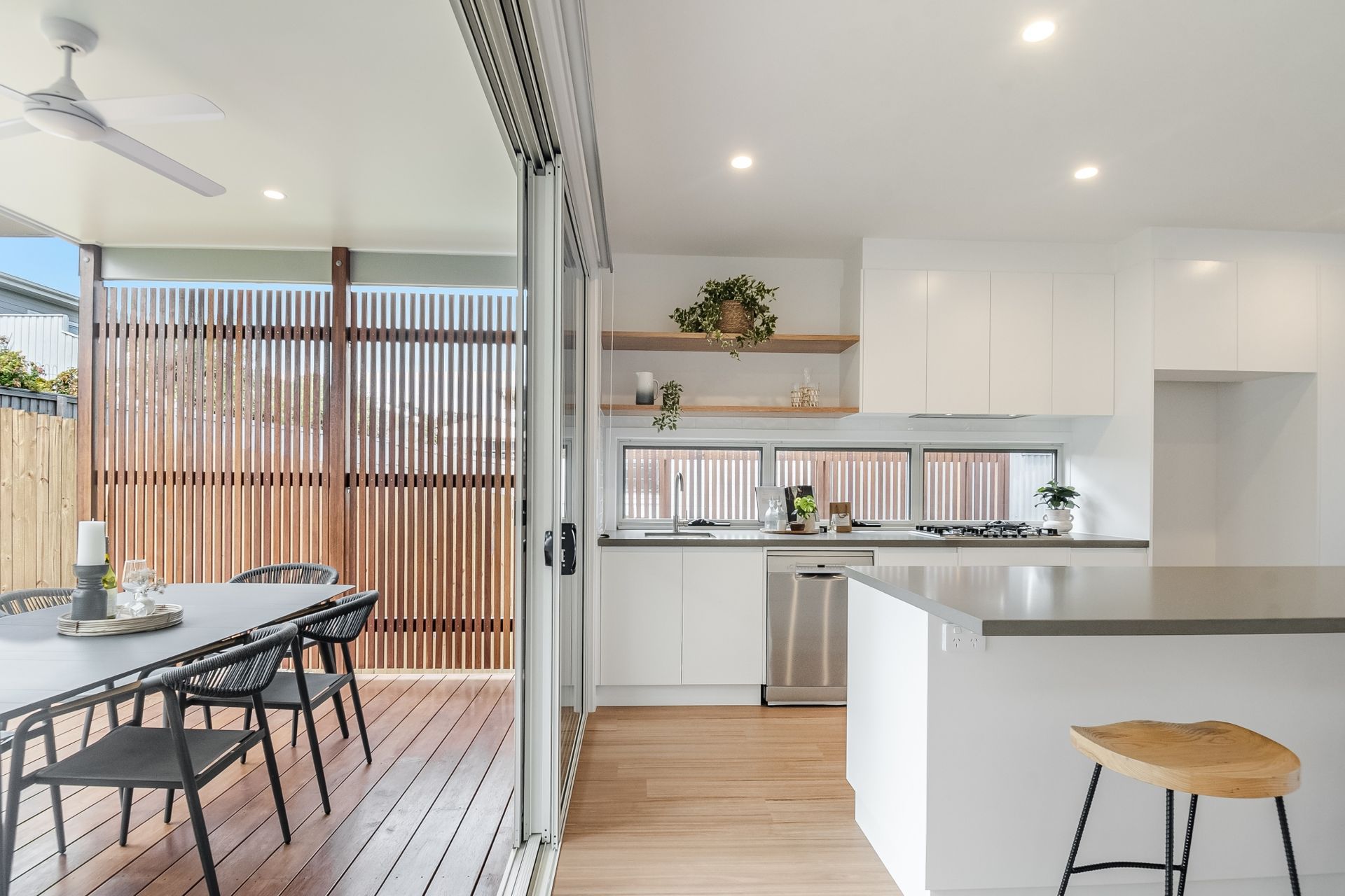 A kitchen with a table and chairs and a ceiling fan.