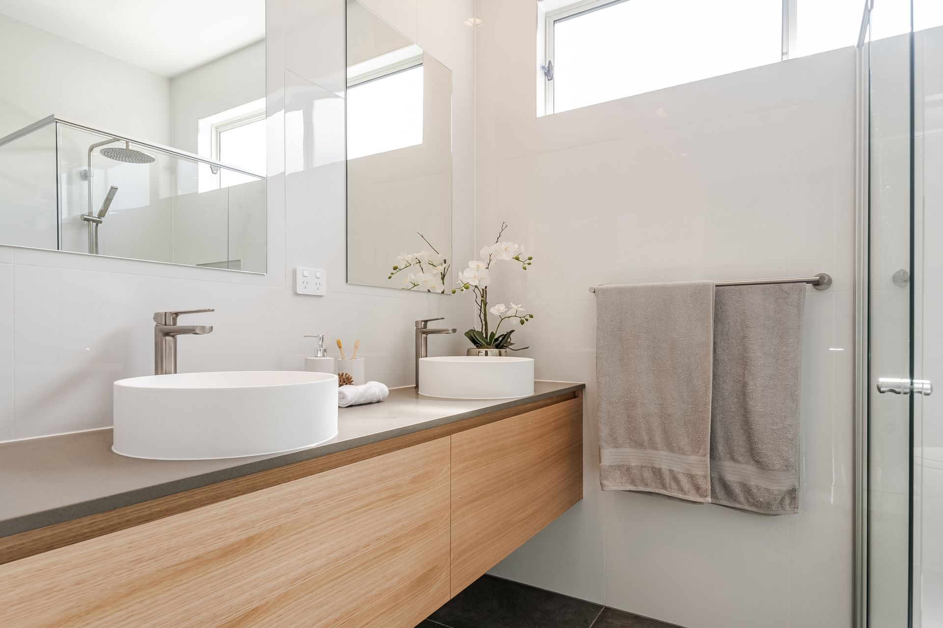 A bathroom with a sink , mirror and shower.