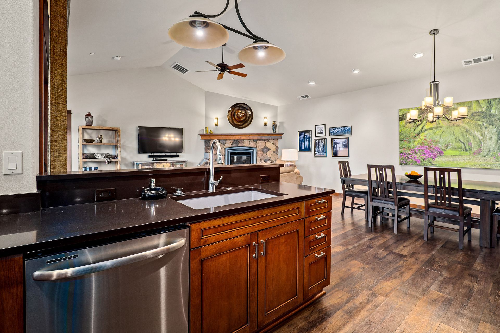 Modern kitchen with dark wood island, open dining area, and fireplace in the background