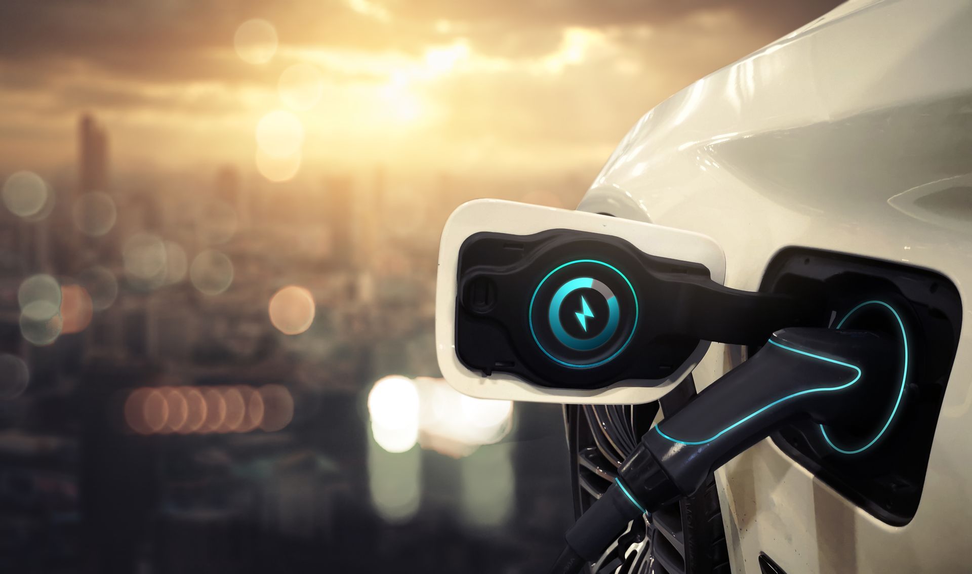 A white electric vehicle charging at a station against a blurred city skyline at sunset.
