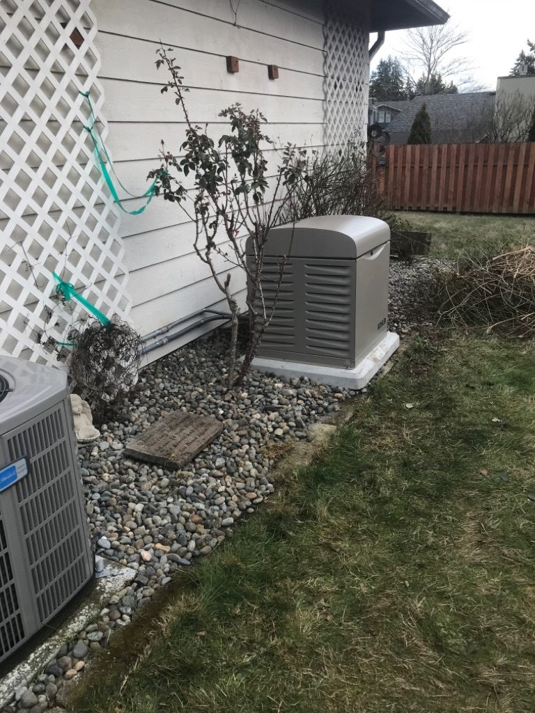 A person inspecting the engine of an open outdoor standby generator mounted on a concrete pad. A person inspecting the engine of an open outdoor standby generator mounted on a concrete pad.