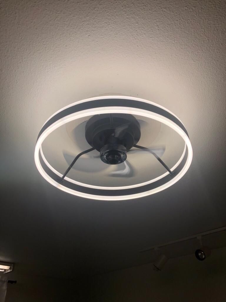 Round ceiling light fixture with a glowing white ring in a dim room