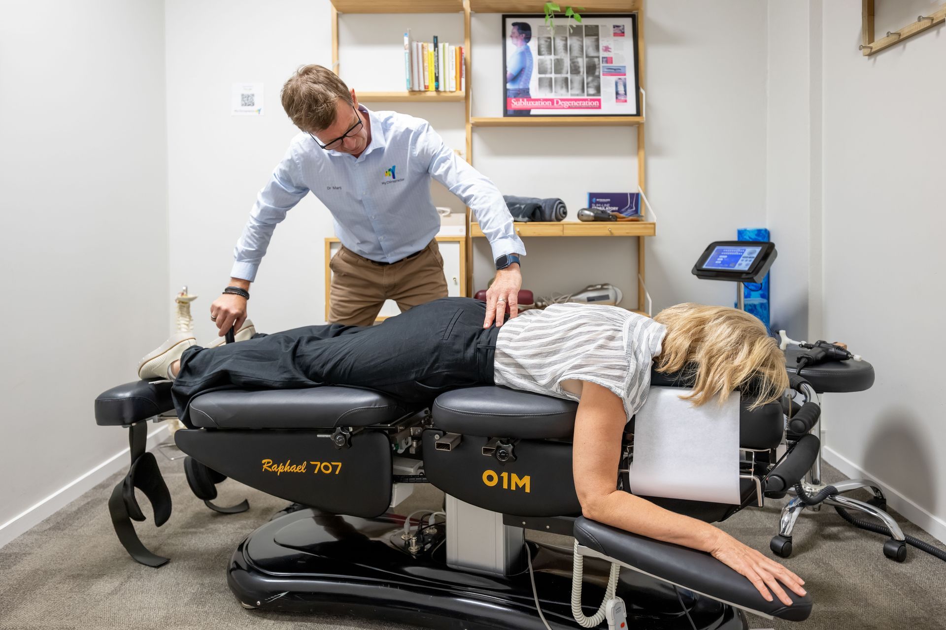 Chiropractor Adjusting a Patient Lying Face Down on A Treatment Table — My Chiropractor Mackay City in Mackay, QLD