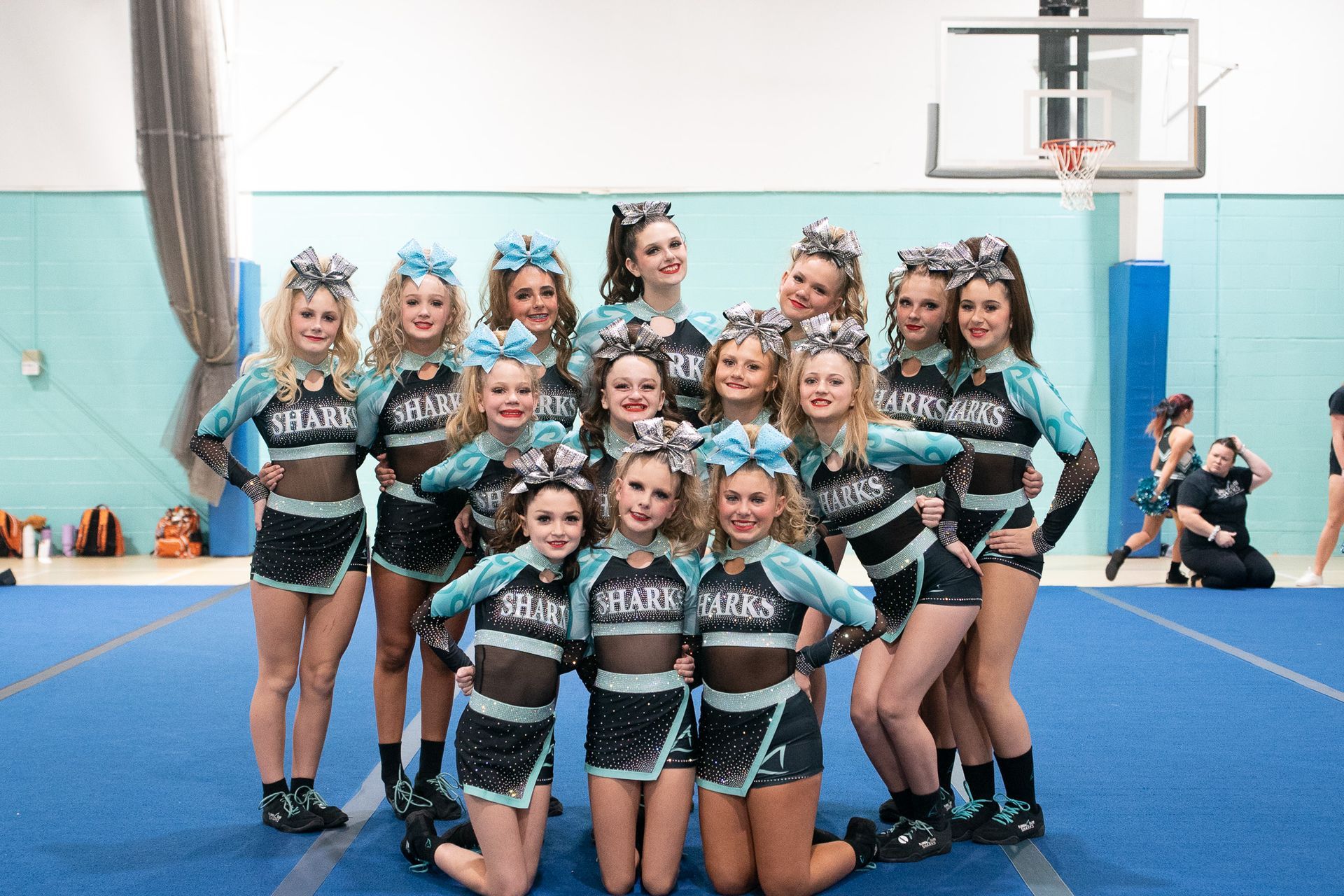 A group of cheerleaders are posing for a picture.