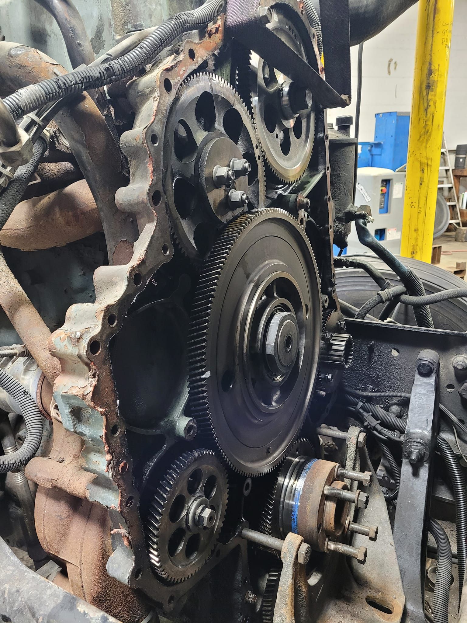 The front view of a disassembled heavy-duty diesel engine, showing the exposed timing gears and drive components.