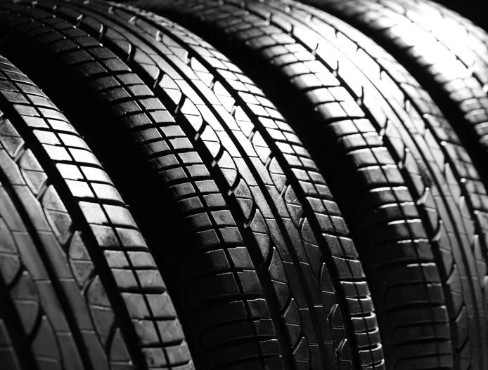 Close-up of stacked black tires with shiny tread patterns