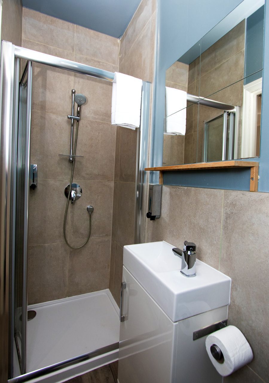A bathroom with a shower a sink and a mirror