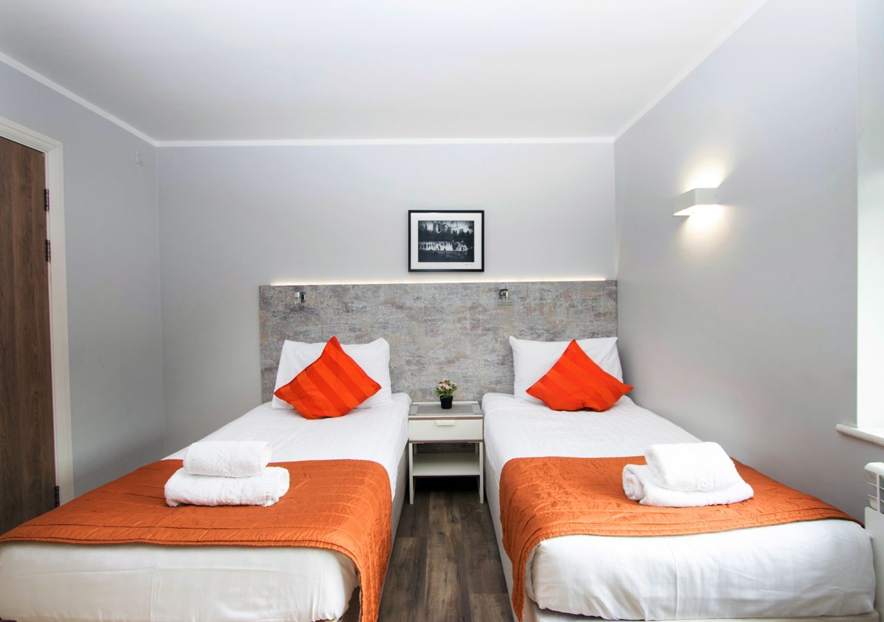 A hotel room with two beds and a picture on the wall.
