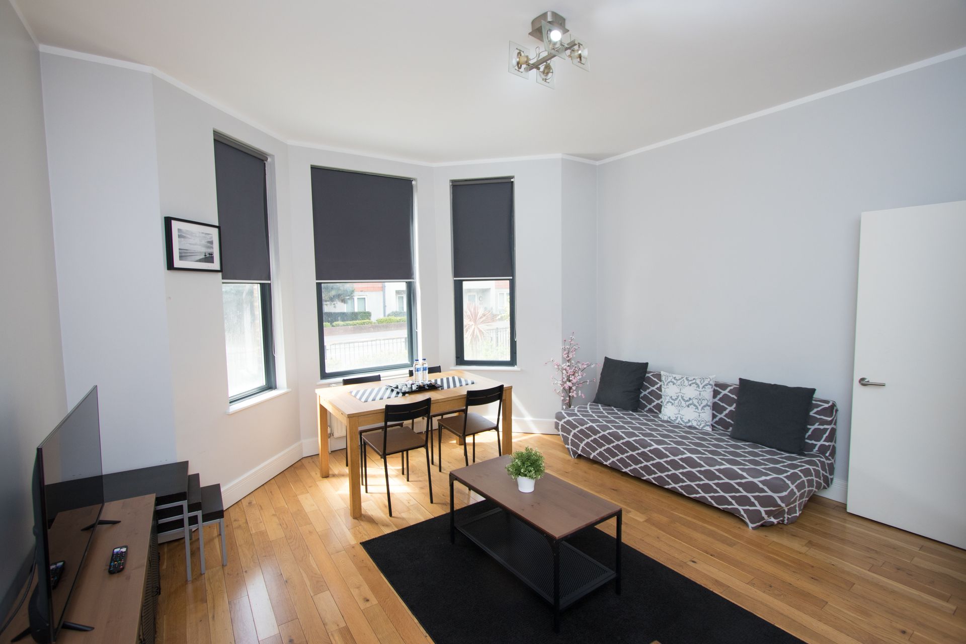 A living room with a couch , table and chairs