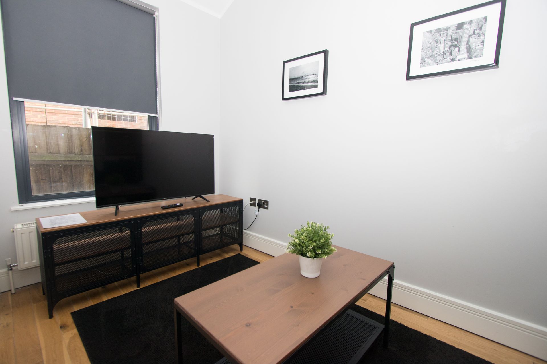 A living room with a flat screen tv and a coffee table.