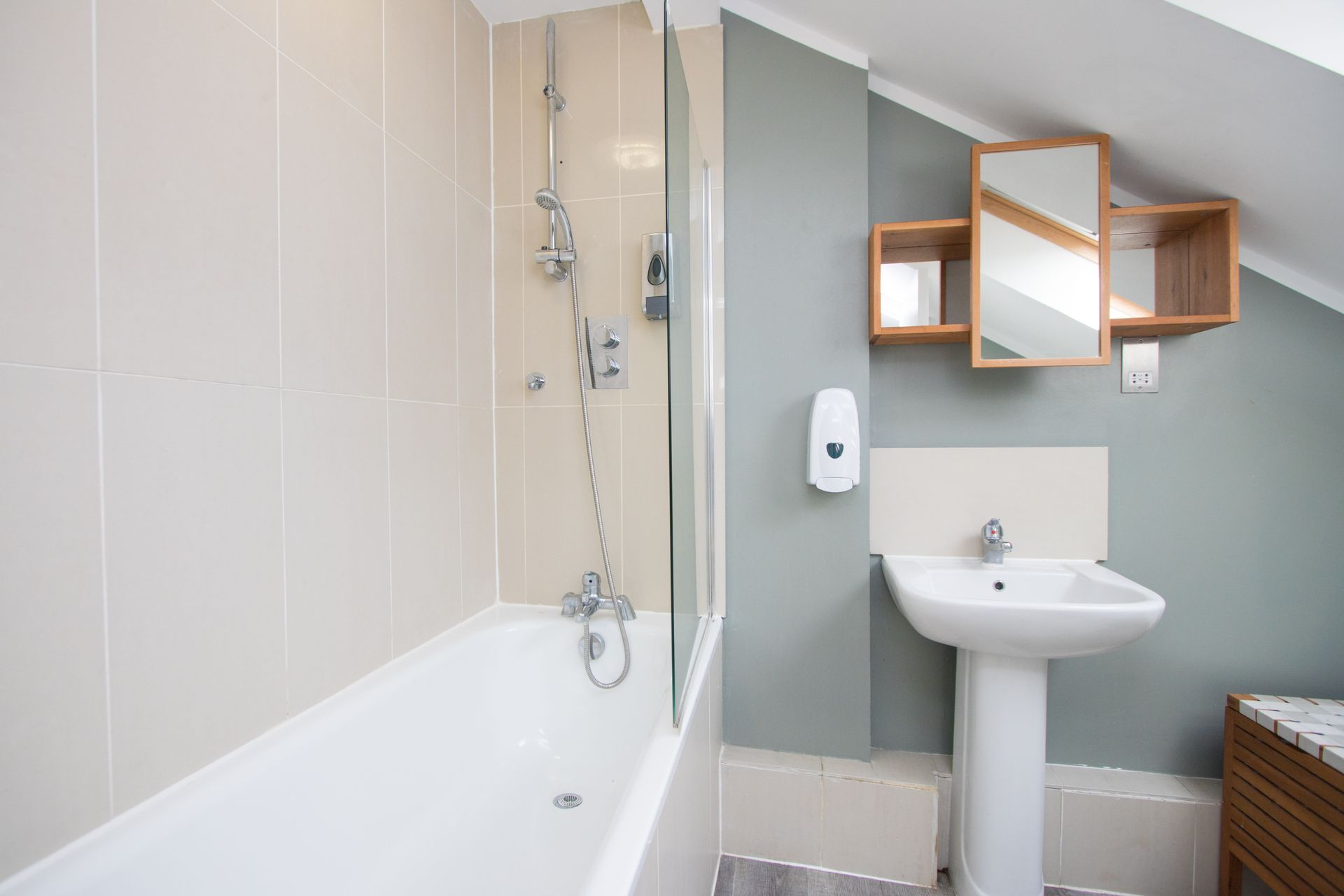 A bathroom with a sink , bathtub and shower.