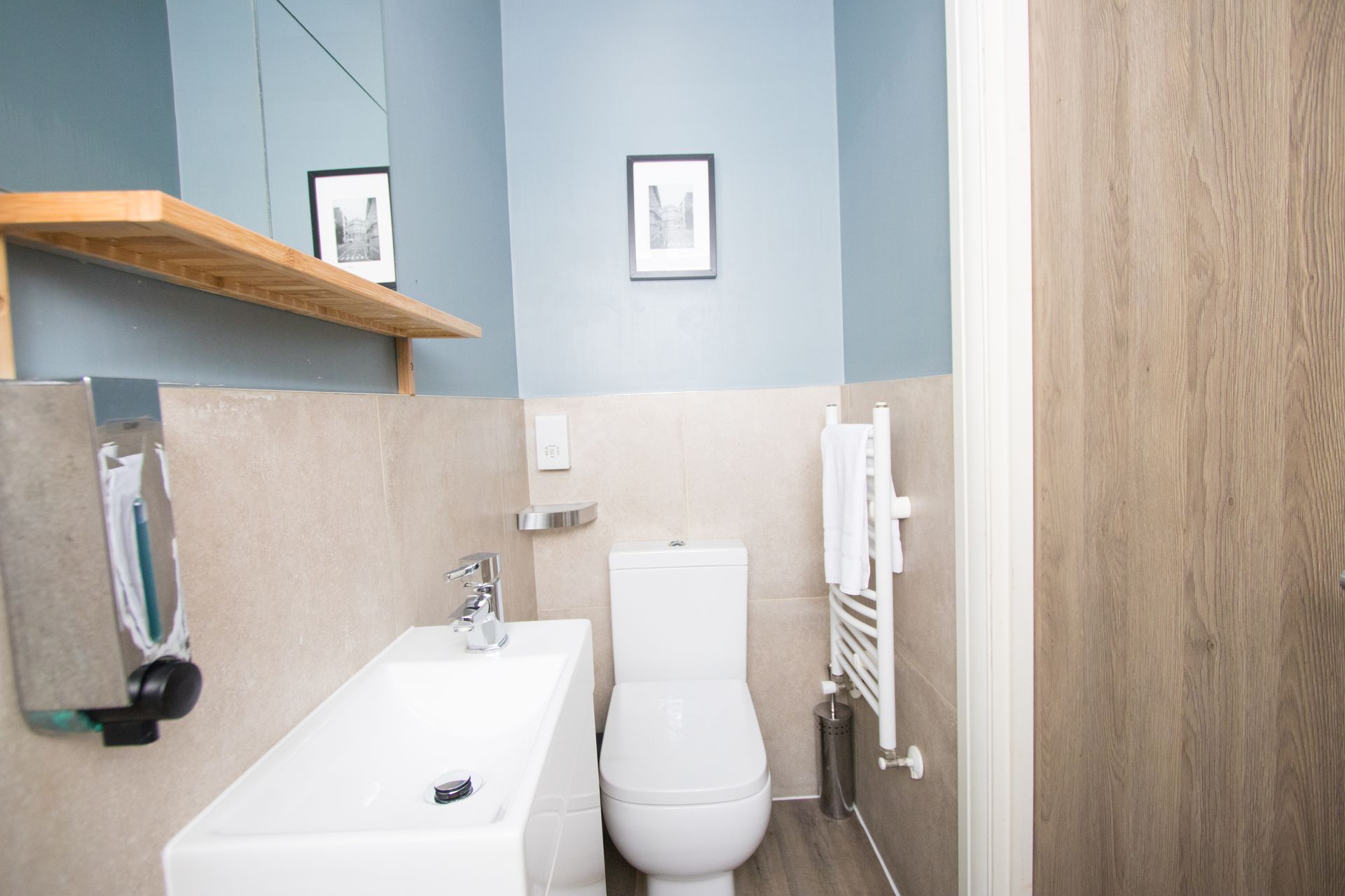 A bathroom with a toilet , sink and mirror.