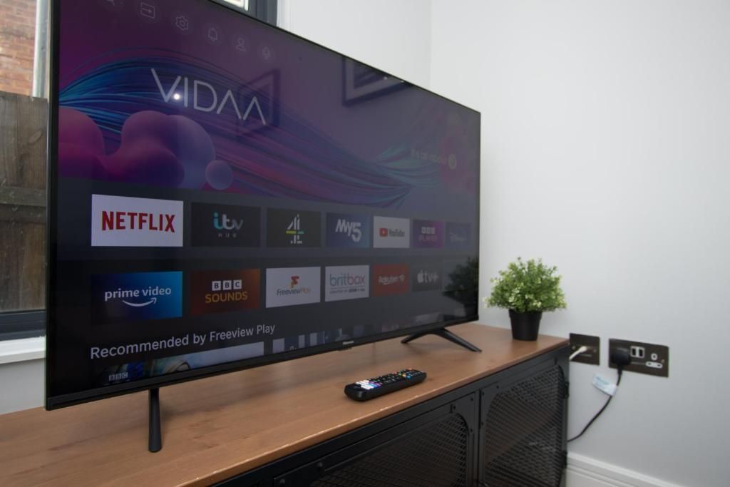A flat screen tv is sitting on top of a wooden entertainment center.