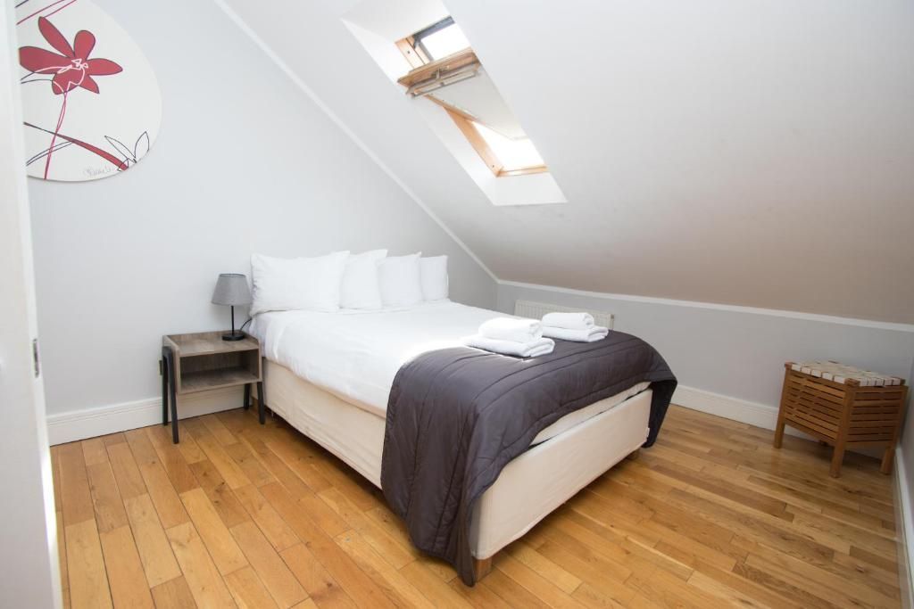 A bedroom with a king size bed and hardwood floors