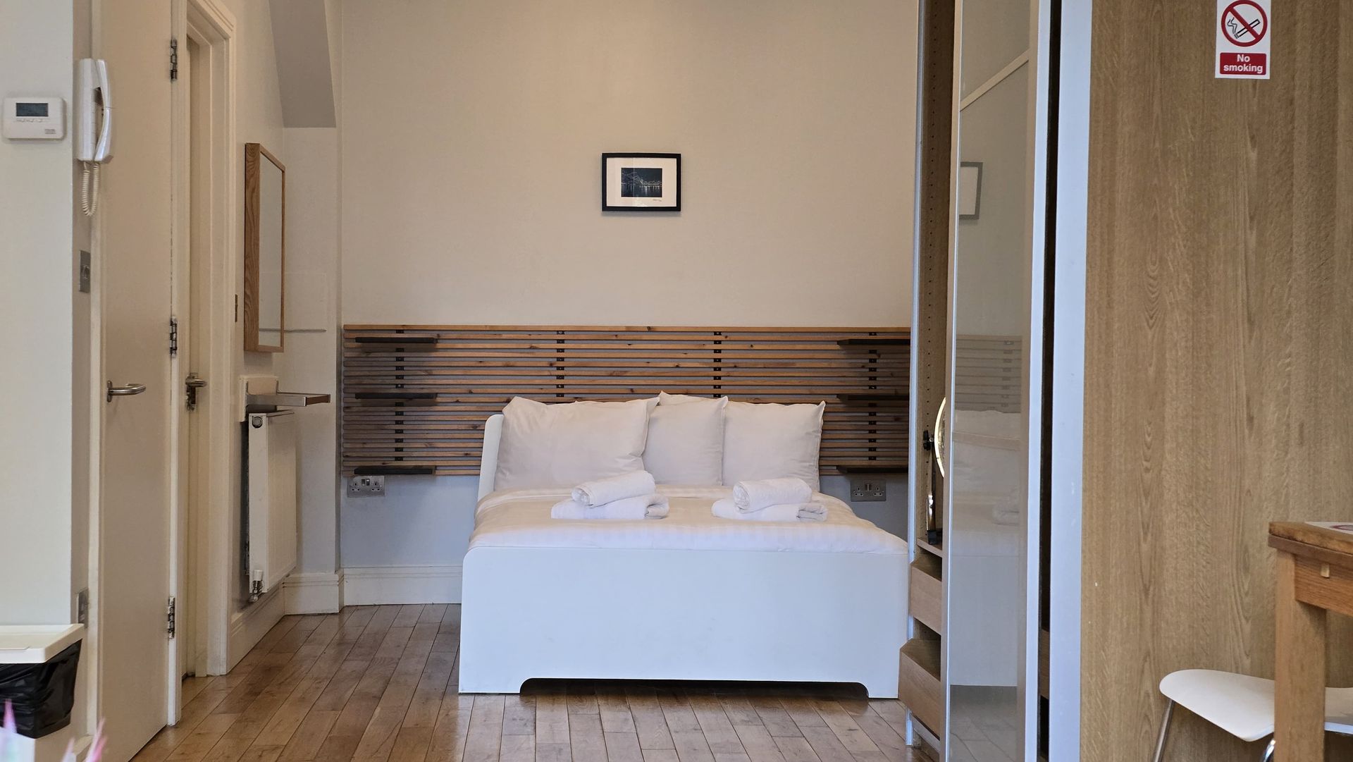 Bed against wall and a closet with a mirror