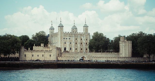 The tower of london is a large castle sitting on top of a body of water.