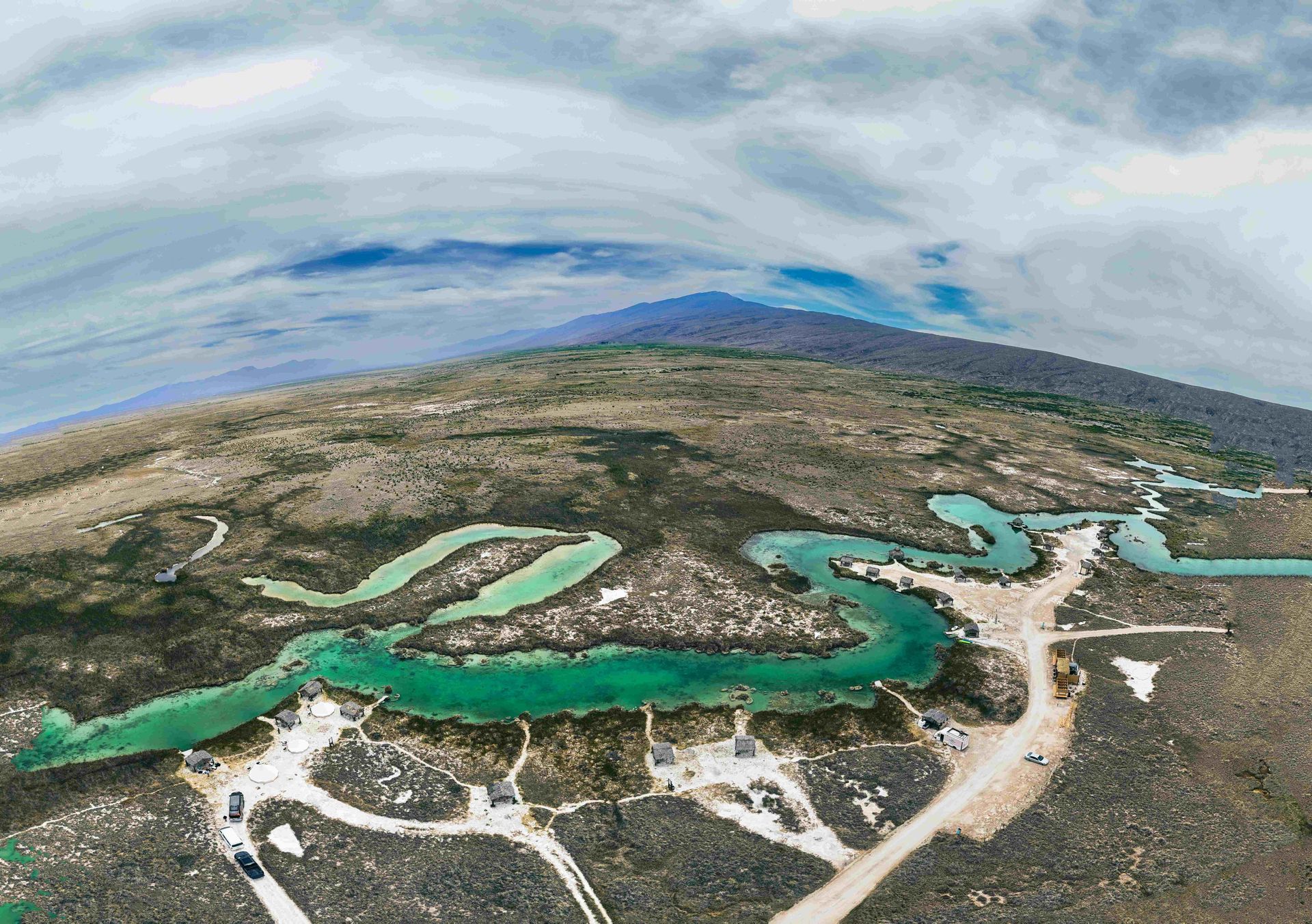 Una vista aérea de un lago con montañas al fondo.