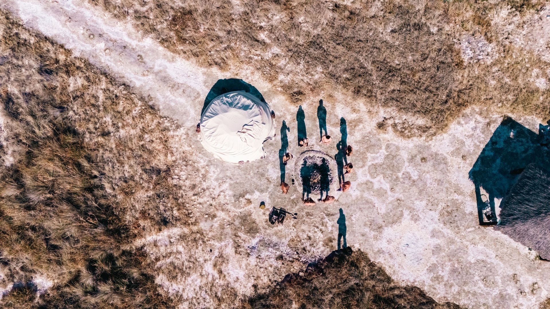 Una vista aérea de un grupo de personas haciendo parasailing en el desierto.