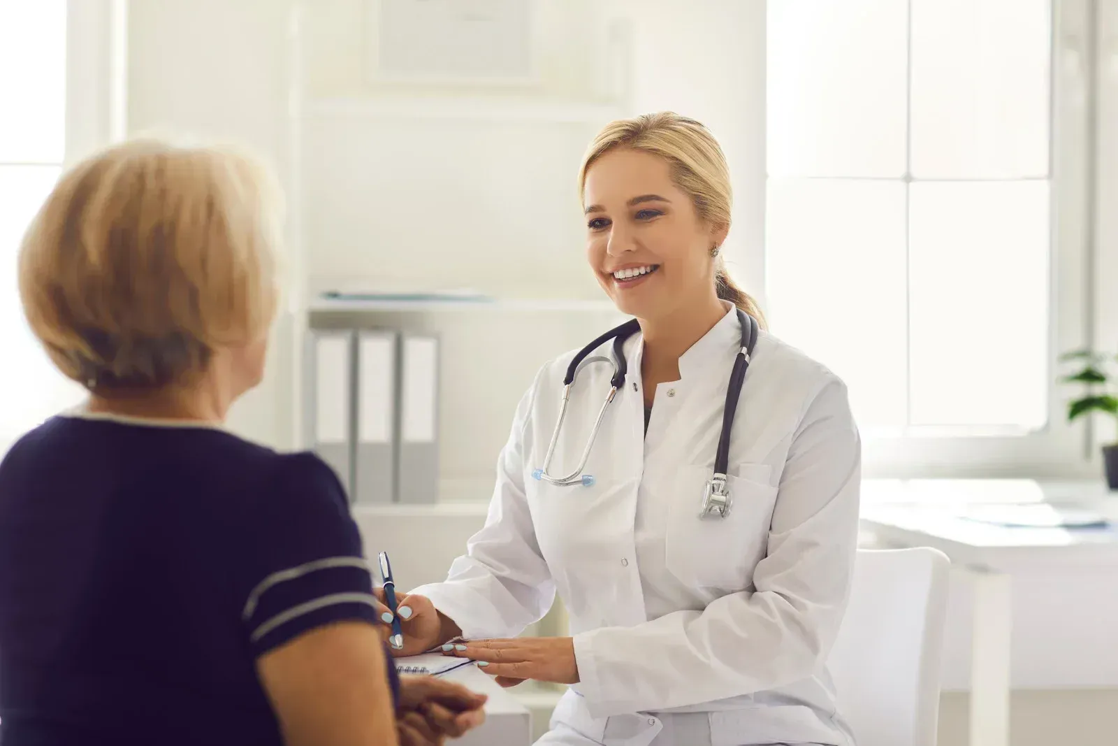 Doctor smiling with patient in bright clinic office