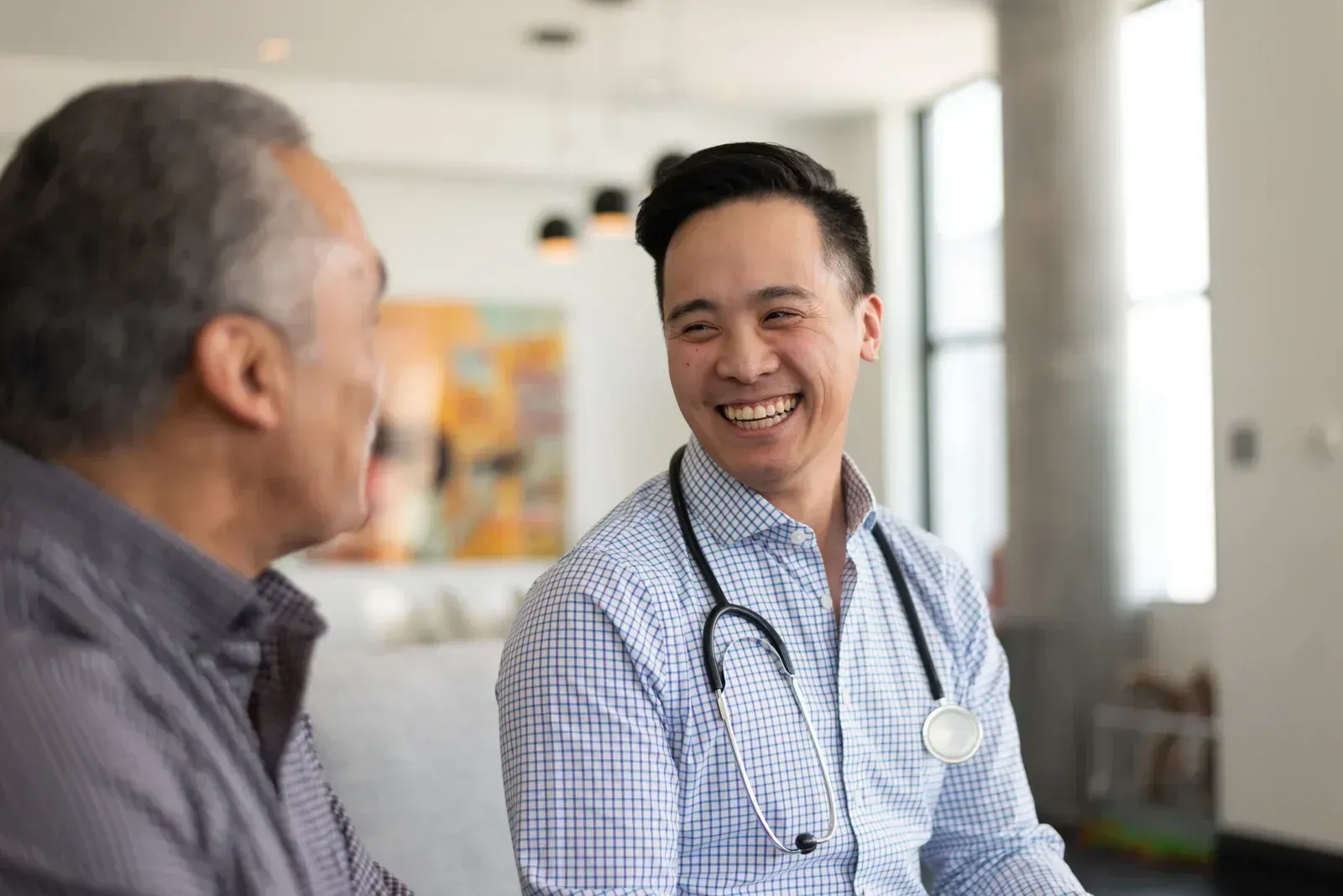 Doctor smiling and talking with a patient in a bright clinic waiting area