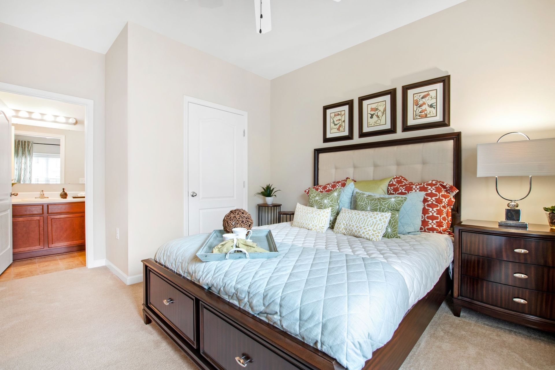 Bedroom in apartment with a dark wood bed, tufted headboard, and matching nightstands.