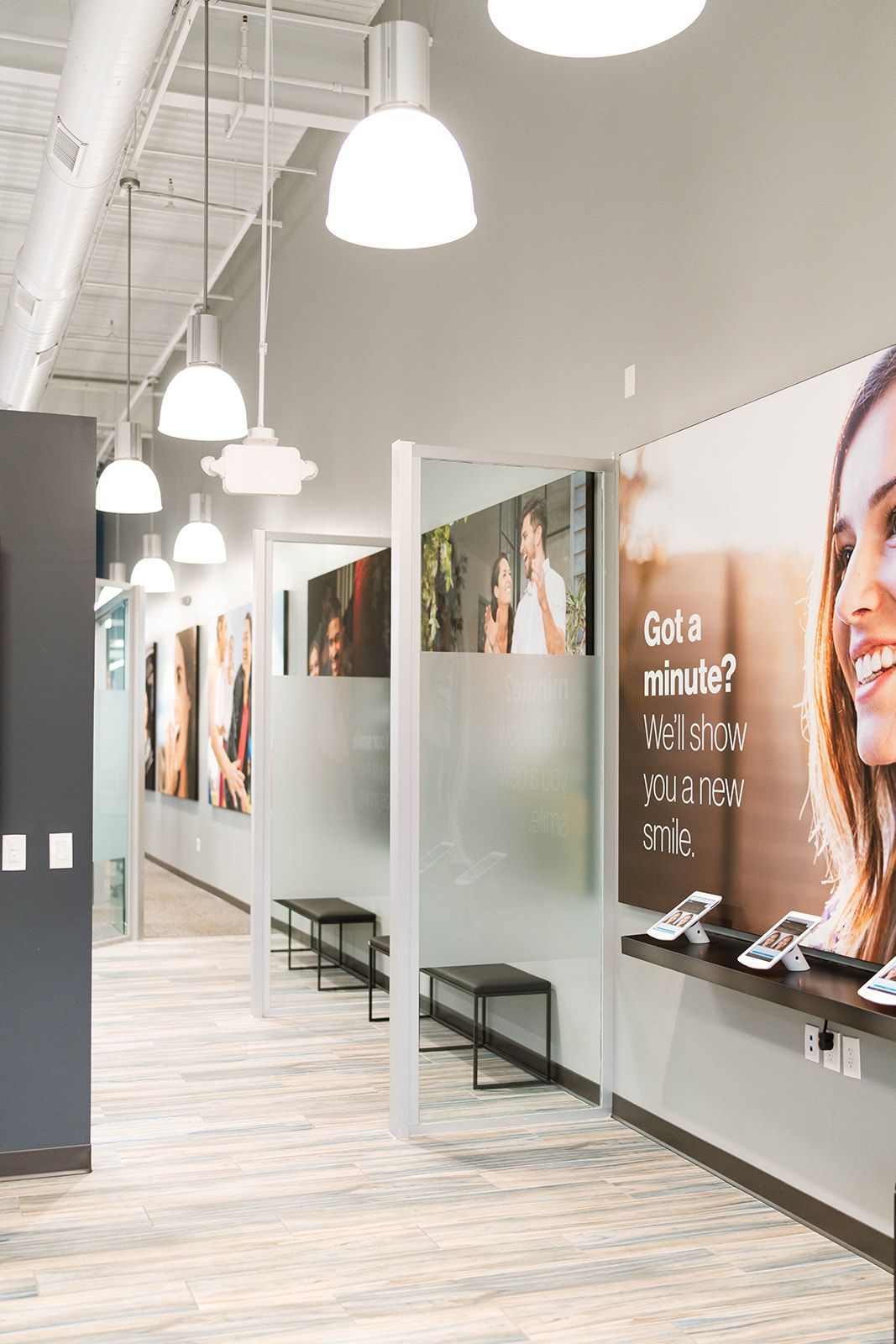 Interior of a store with display shelves, seating areas, and advertising posters under white lights.
