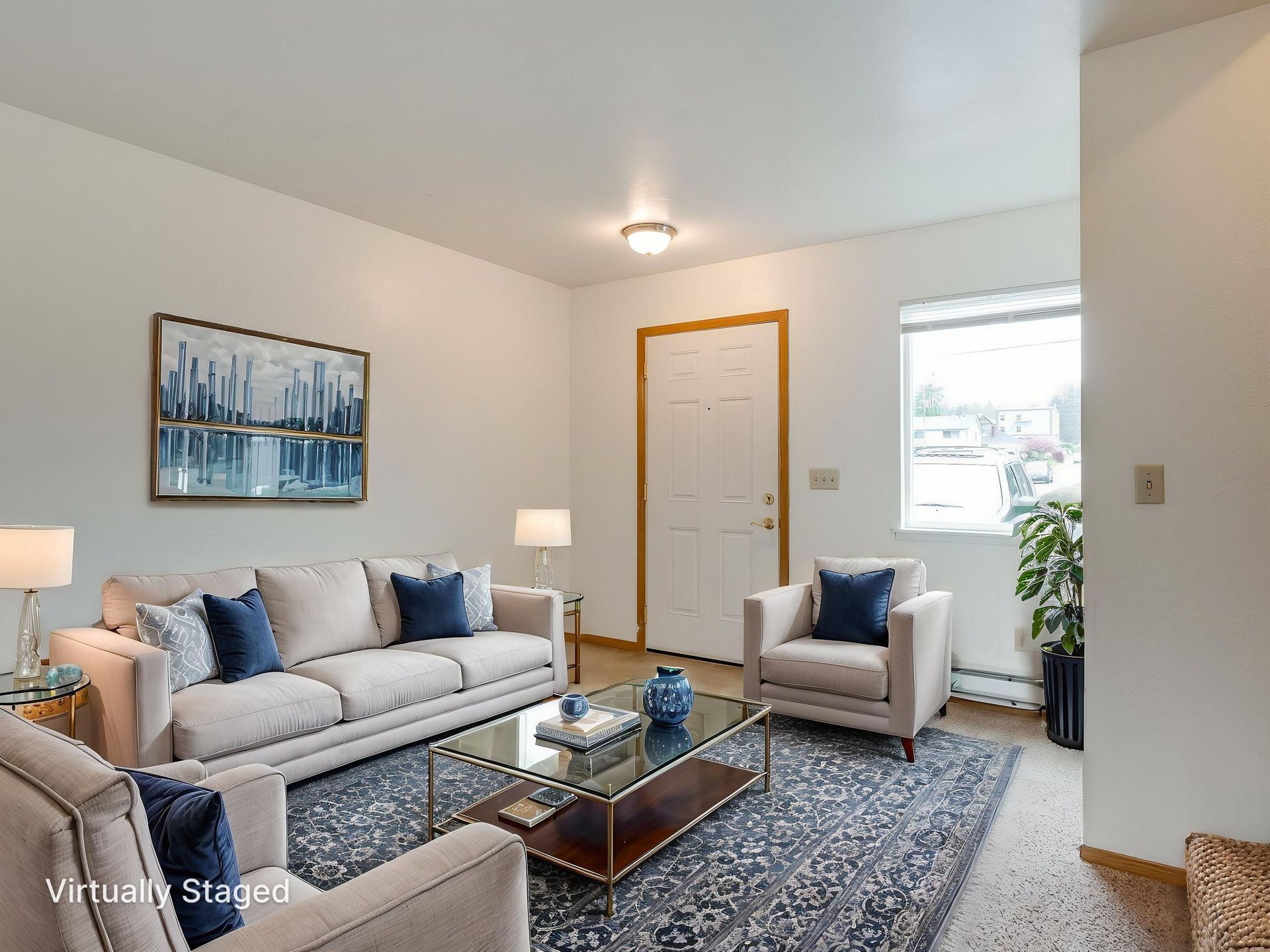 Southridge Apartments Townhome spacious living room with view of front door and window virtually staged.