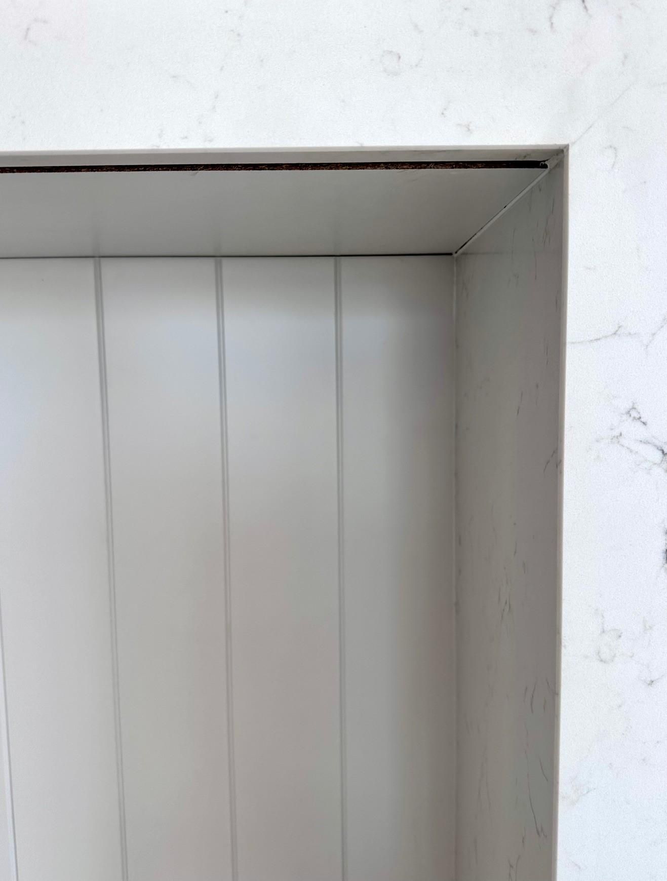 A close up of a white door with a marble counter top.