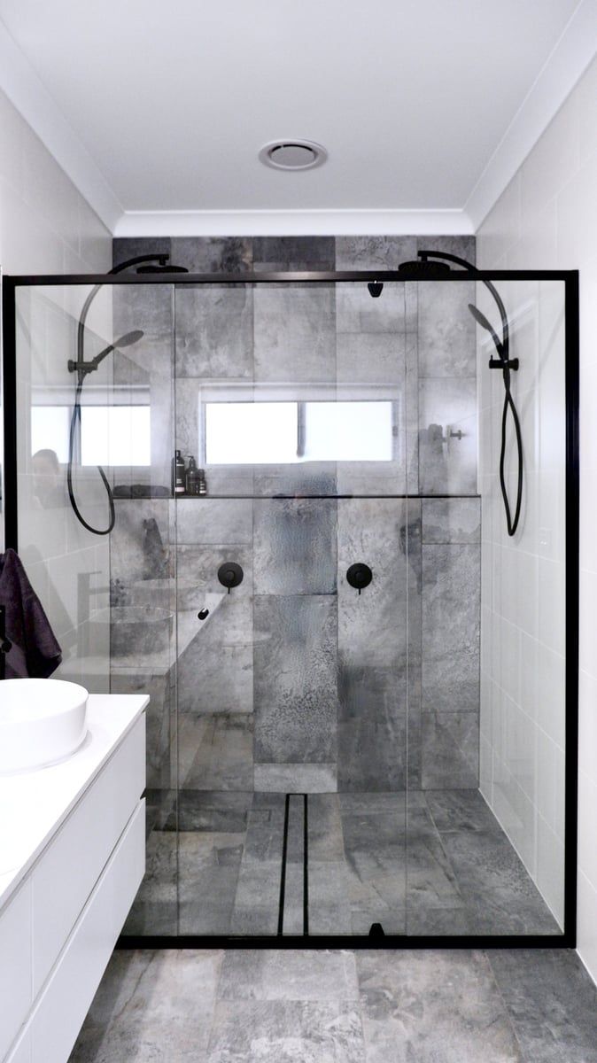 A bathroom with a walk in shower and a sink.