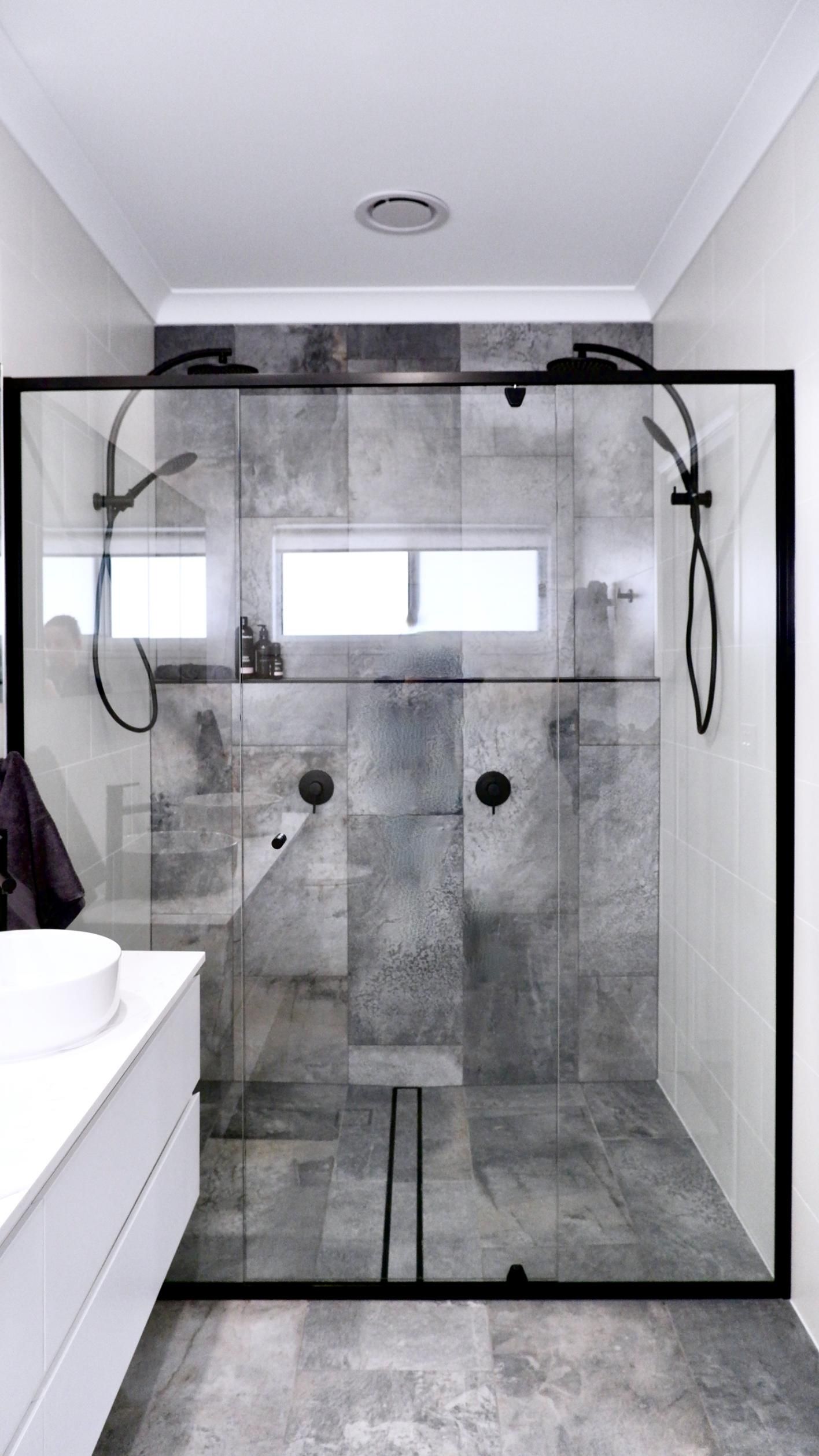 A bathroom with a walk in shower and a sink.