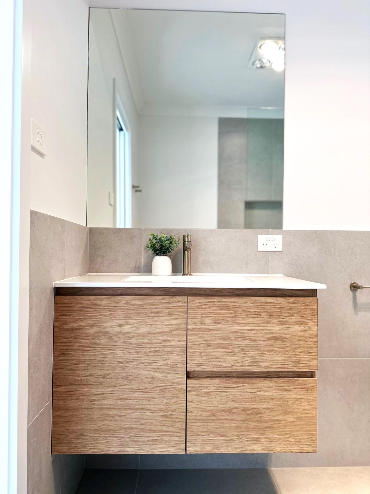 A kitchen with white cabinets , stainless steel appliances , a refrigerator and a sink.