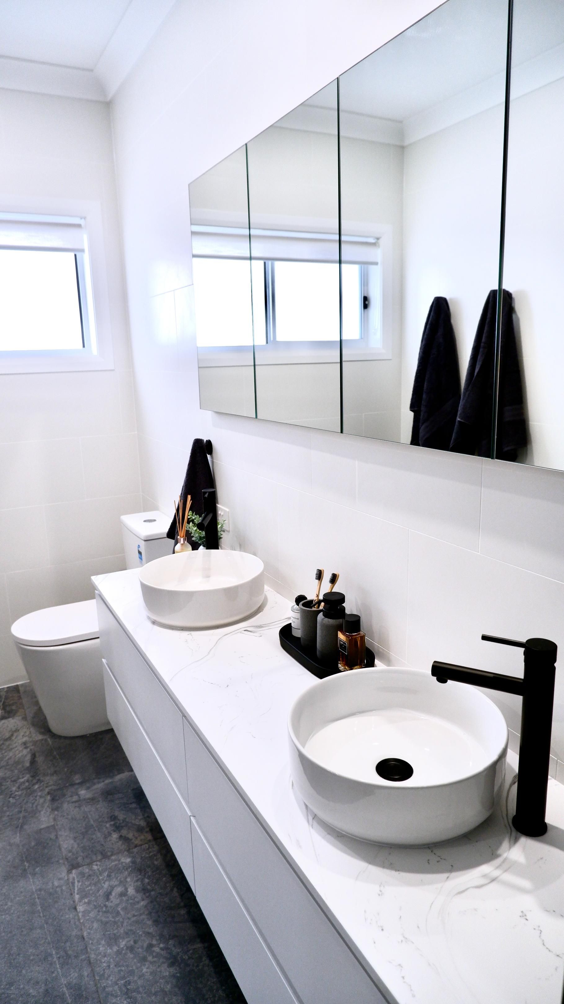 A bathroom with two sinks , a bathtub , and a walk in shower.
