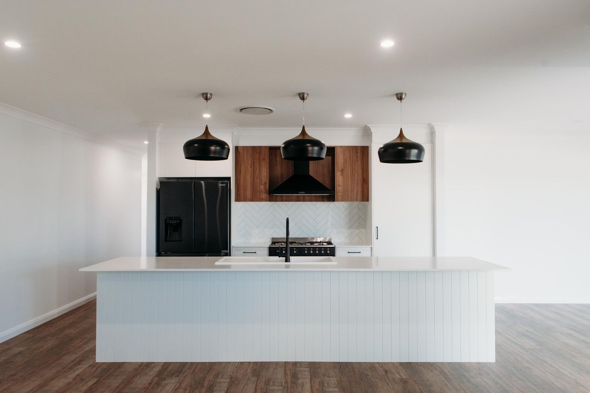 An empty kitchen with a large island in the middle of the room.