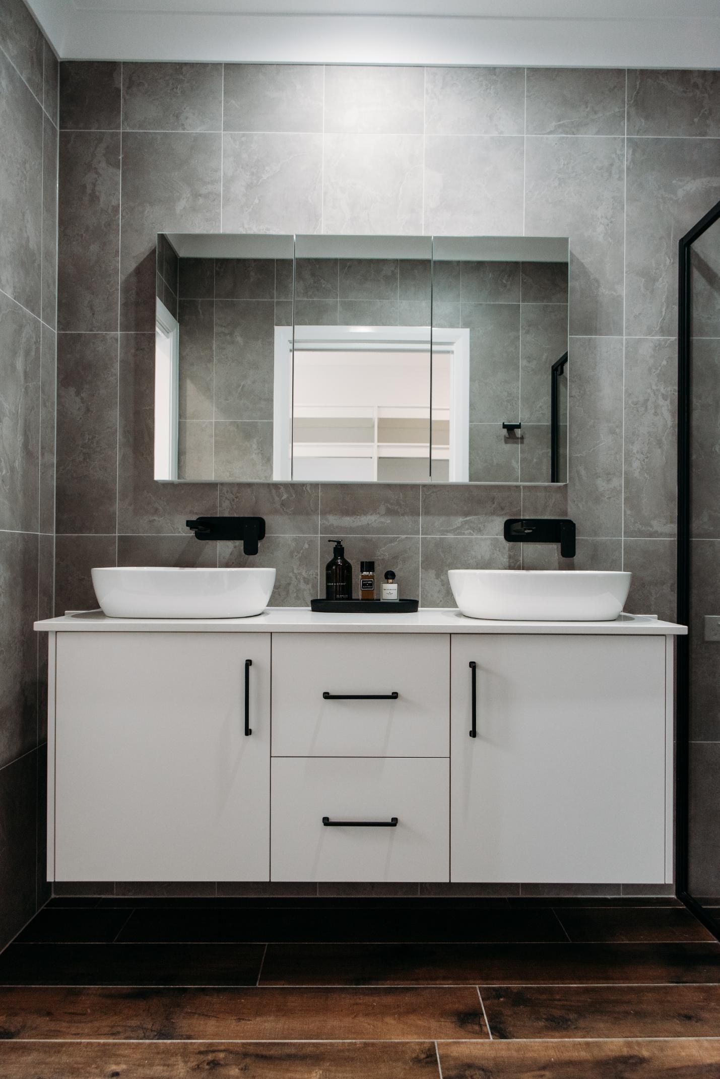 An empty kitchen with black appliances and white cabinets