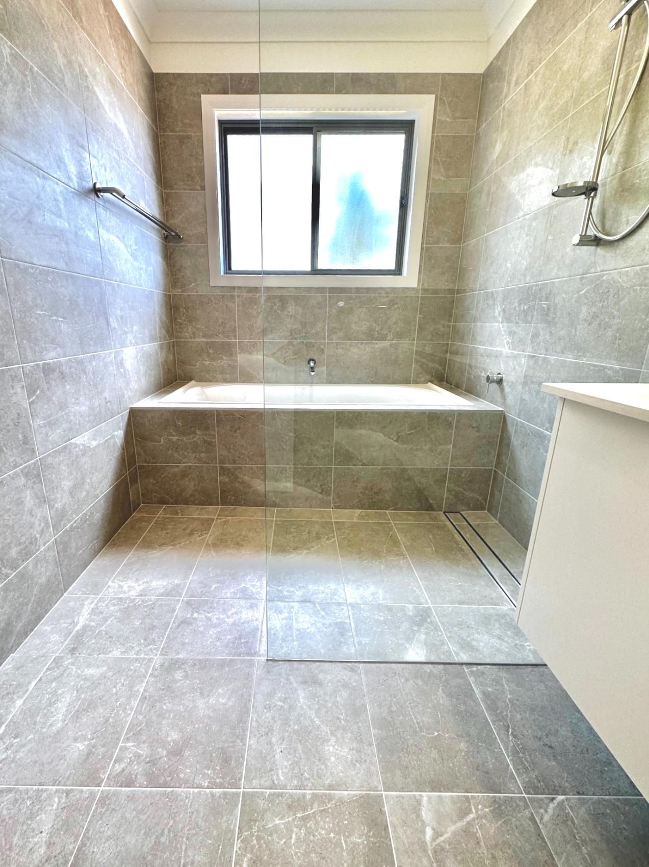 A bathroom with a bathtub and a window.