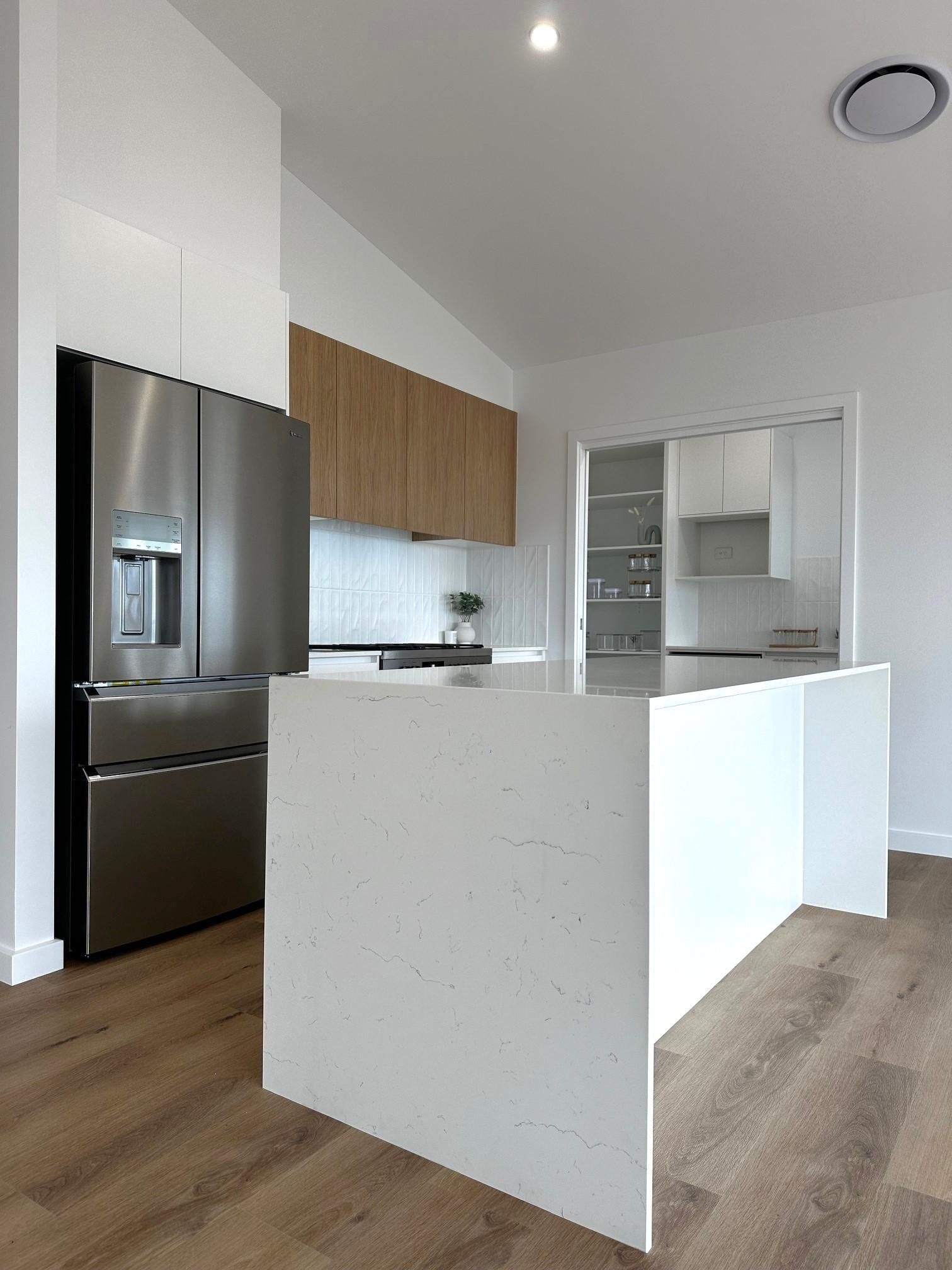 A kitchen with a large island and stainless steel appliances.
