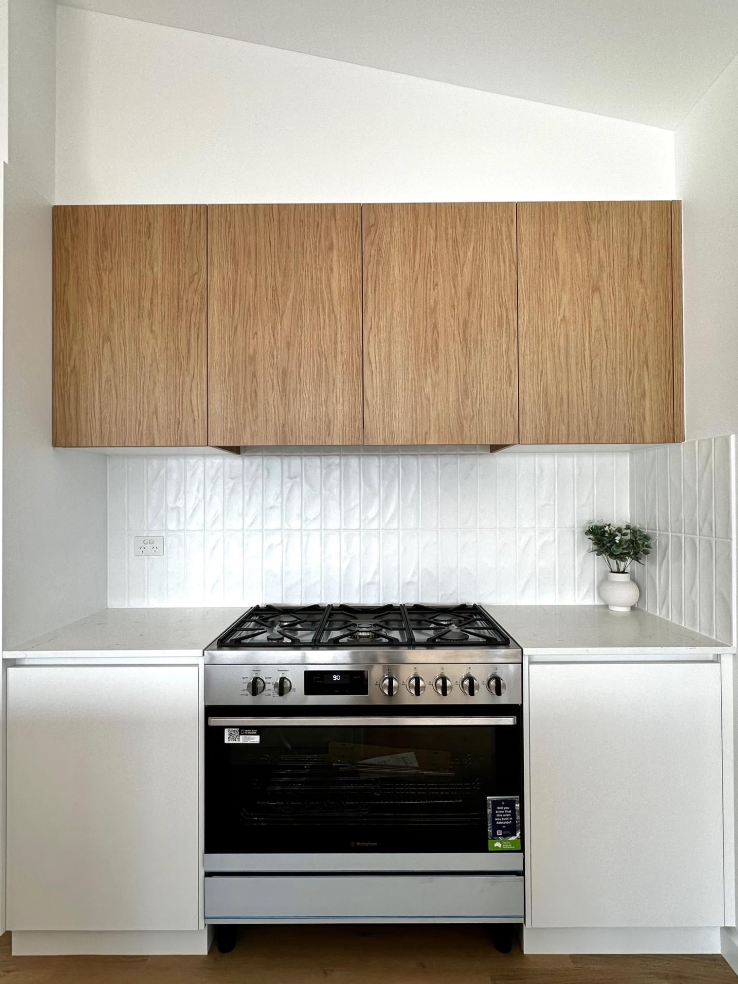 A kitchen with stainless steel appliances and wooden cabinets.