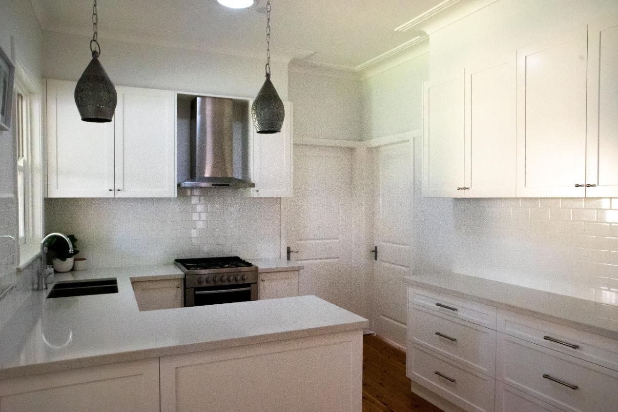 A kitchen with white cabinets and stainless steel appliances.