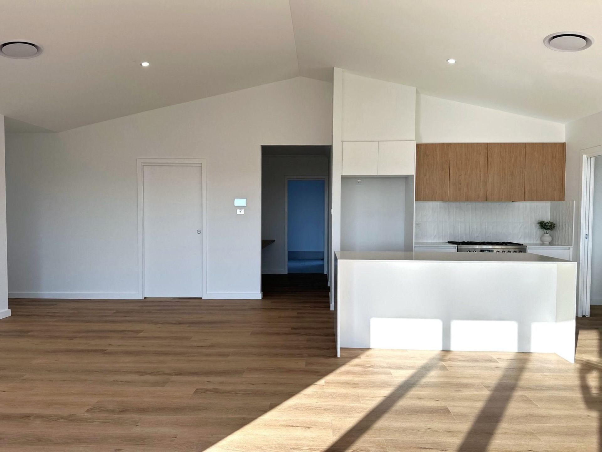 A kitchen with wooden floors and white cabinets