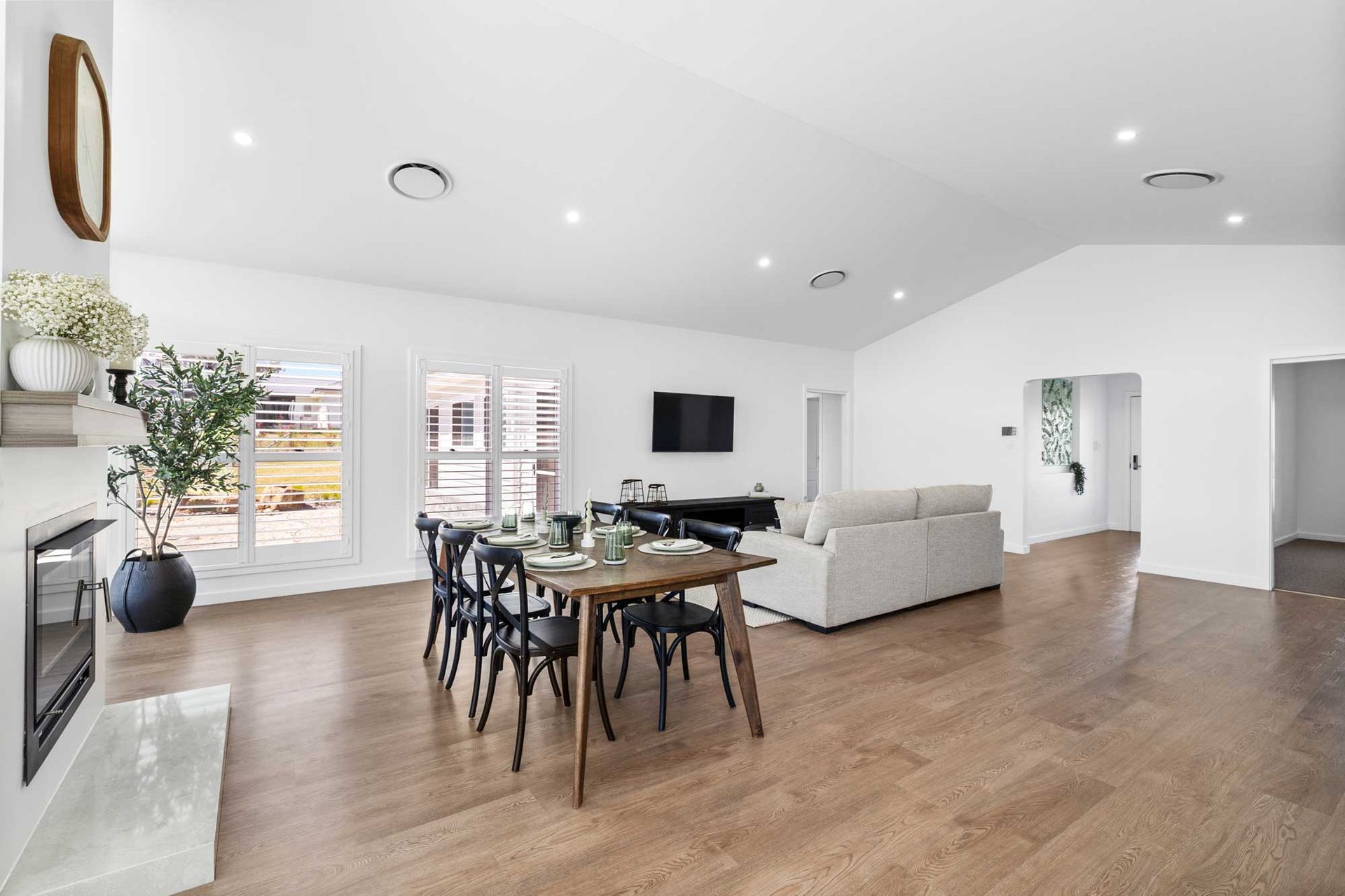 A large empty room with hardwood floors and lots of windows.